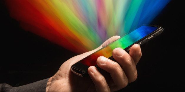 Streaks of multi colored light coming from smartphone held in man's hand