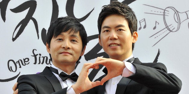 Kim Jho Gwang-Soo (L), a South Korean movie director who is gay, and his partner Kim Seung-Hwan (R), a colleague at his entertainment firm, pose during a press conference before their wedding in central Seoul on September 7, 2013. The prominent gay rights campaigner and movie director 'married' his partner in South Korea where same-sex marriage is not legally recognised. AFP PHOTO / JUNG YEON-JE (Photo credit should read JUNG YEON-JE/AFP/Getty Images)