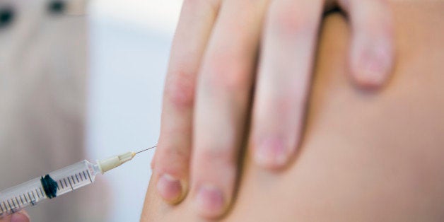 Cropped image of doctor injecting patient in clinic