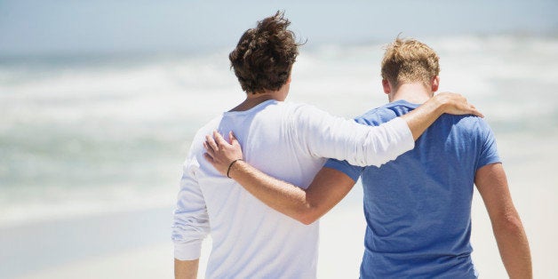 Rear view of two men walking with their arms around each other