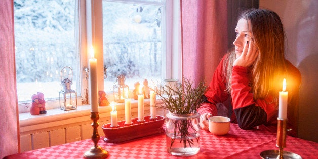 Young woman looking through window