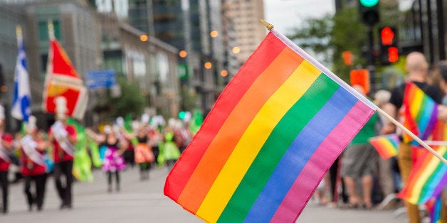 Gay rainbow flags at Montreal gay pride parade with blurred spectators in the background