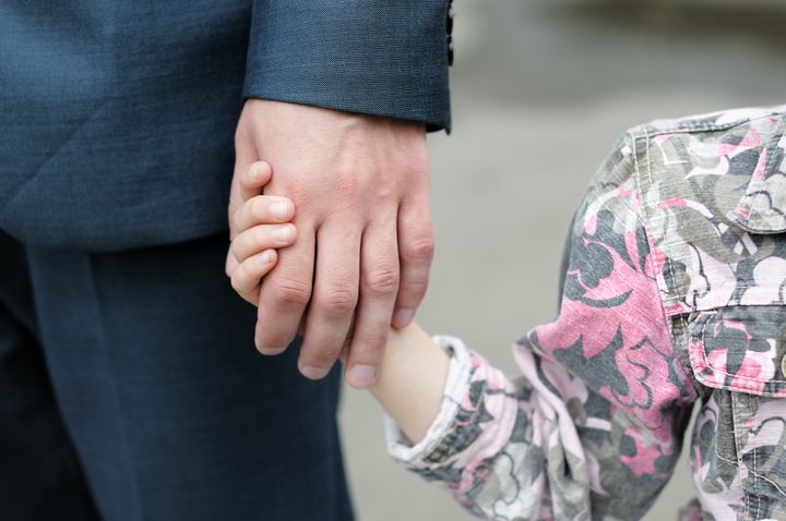 Closeup of a small girl holding a man's hand