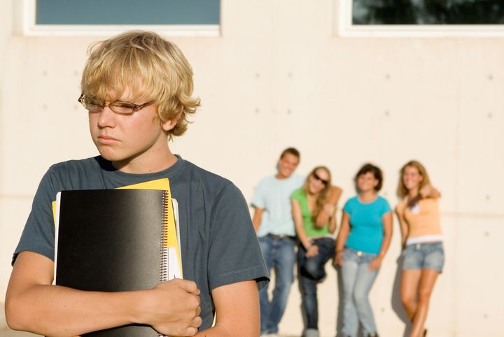 students boy being bullied by other group of students