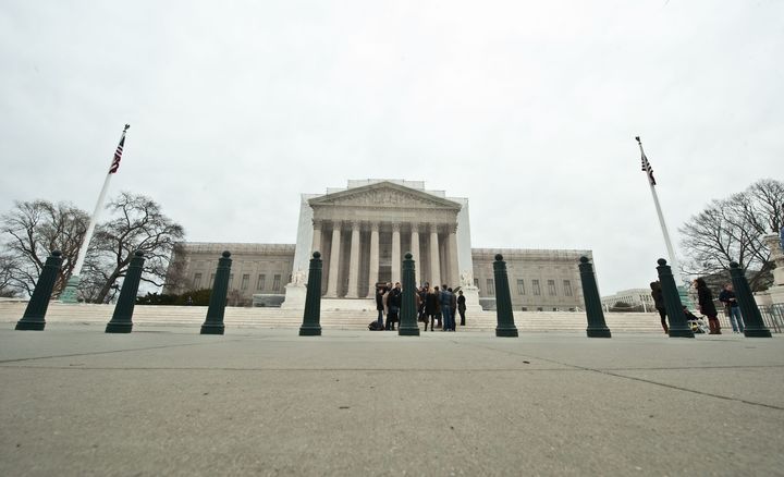 Tourists stand in front of the Supreme Court in Washington on March 24, 2013 as people begin lining up for the court's upcoming coming hearings on gay marriage. The justices will hear arguments on March 26 on California's Proposition 8 ban on same-sex marriage and on March 27 on the federal Defense of Marriage Act, which defines marriage as between one man and one woman. AFP PHOTO/Nicholas KAMM (Photo credit should read NICHOLAS KAMM/AFP/Getty Images)