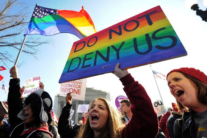 Same-sex marriage supporters shout slogans in front of the US Supreme Court on March 26, 2013 in Washington, DC. The US Supreme Court on Tuesday takes up the emotionally charged issue of gay marriage as it considers arguments that it should make history and extend equal rights to same-sex couples. Waving US and rainbow flags, hundreds of gay marriage supporters braved the cold to rally outside the court along with a smaller group of opponents, some pushing strollers. Some slept outside in hopes of witnessing the historic hearing. AFP PHOTO/Jewel Samad (Photo credit should read JEWEL SAMAD/AFP/Getty Images)