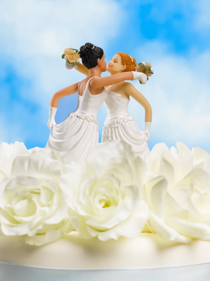 Two female bride figurines on top of wedding cake, close up