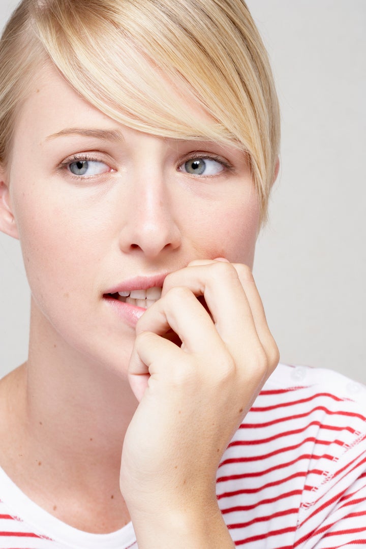 Woman looking away, hand near mouth, close-up