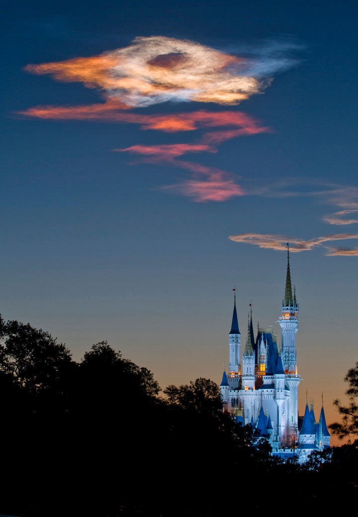 LAKE BUENA VISTA, FL - APRIL 05: In this handout photo provided by Disney, the sunrise over Cinderella Castle in the Magic Kingdom creates a multi-colored effect in the sky as the sun shines through the trail left after Space Shuttle Discovery launched from nearby Cape Canaveral on April 5, 2010 in Lake Buena Vista, Florida. At 6:21 a.m. EDT, Space Shuttle Discovery lifted off from Cape Canveral, Florida with the crew of STS-131. (Photo by Kent Phillips/Disney via Getty Images)