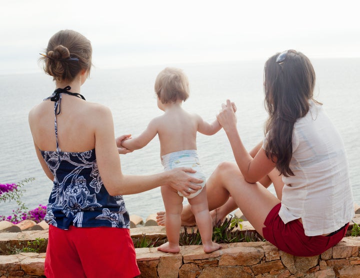 women holding baby's hand