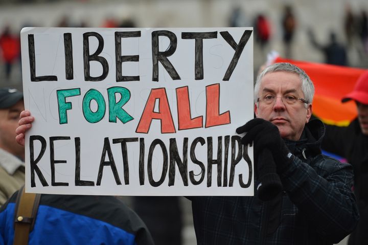 A protester holds up a placard that reads 'Liberty for all relationships' as he joins a demonstration for equal rights for gay couples in Trafalgar Square cental London on March 24, 2013 countering an Anglo-French protest against a controversial bill to legalise same-sex marriage and adoption in France. France's National Assembly endorsed thebill to legalise same-sex marriage and adoption on February 12. The bill still has to go to the Senate for examination and approval, but the upper house is unlikely to prevent the groundbreaking reform from becoming law by the summer. AFP PHOTO / BEN STANSALL (Photo credit should read BEN STANSALL/AFP/Getty Images)