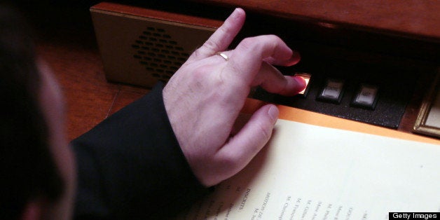 A French member of Parliament pushes a button to vote on February 12, 2013 at the French National Assembly in Paris, during t