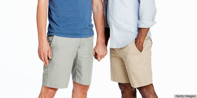 Gay couple kissing against white background