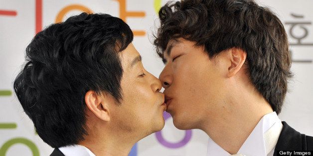 Kim Jho Gwang-Soo (L), a South Korean movie director who is gay, kisses his partner Dave Kim (R) during a press conference to disclose their wedding plans in Seoul on May 15, 2013. The director is one of a few South Korean movie workers who have come out as gay, but his marriage will not be formally recognized under South Korean law. AFP PHOTO / JUNG YEON-JE (Photo credit should read JUNG YEON-JE/AFP/Getty Images)