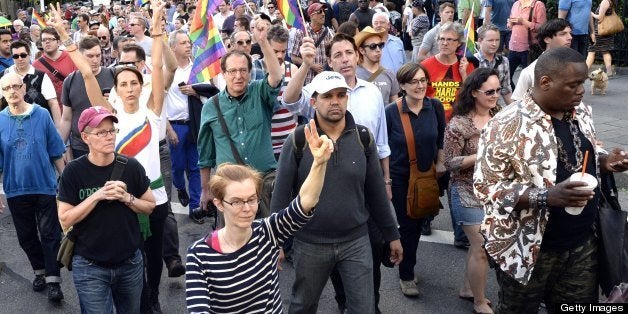 Marchers make their way throught the West Village to make their way to the spot where a makeshift shrine is set on the location where Mark Carson, 32, a gay man, was shot dead in what police are calling a hate crime in Greenwich Village in New York, May 20, 2013. A suspect identified as Elliot Morales, 33, was arrested on a charge of second degree murder after he used homophobic slurs before firing a fatal shot point-blank into a Carson's face overnight May 17, 2013. AFP PHOTO / TIMOTHY CLARY (Photo credit should read TIMOTHY CLARY/AFP/Getty Images)