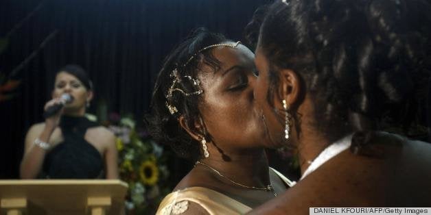 Brazilians Mikelly de Jesus, 44, and her bride Leia de Jesus (R), 29, kiss during a collective gay marriage ceremony, in Sao Paulo, Brazil, on June 13, 2009. The 13th edition of the world's biggest Gay Pride Parade is expected to hold over three million people at the financial centre of Sao Paulo Sunday. AFP PHOTO/Daniel KFOURI (Photo credit should read DANIEL KFOURI/AFP/Getty Images)