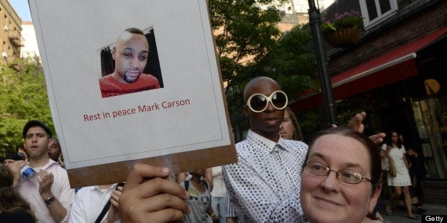 Marchers make their way throught the West Village to make their way to the spot where a makeshift shrine is set on the location where Mark Carson, 32, a gay man, was shot dead in what police are calling a hate crime in Greenwich Village in New York, May 20, 2013. A suspect identified as Elliot Morales, 33, was arrested on a charge of second degree murder after he used homophobic slurs before firing a fatal shot point-blank into a Carson's face overnight May 17, 2013. AFP PHOTO / TIMOTHY CLARY (Photo credit should read TIMOTHY CLARY/AFP/Getty Images)