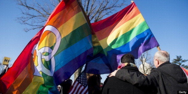 UNITED STATES - MARCH 27: Marcos German Domingues, left, stands with rainbow flags outside the Supreme Court with hundreds of other marriage equality supporters and protesters before oral arguments in the United States v. Windsor case, which will test the constitutionality of the Defense of Marriage Act on March 27, 2013. The Defense of Marriage Act, or DOMA, is a 1996 federal statute defining marriage as the union of one man and one woman. (Photo By Bill Clark/CQ Roll Call)