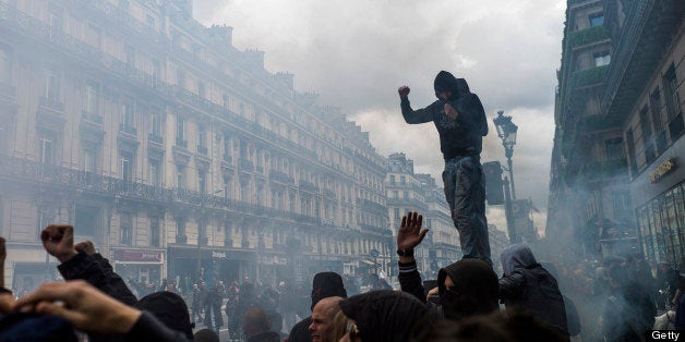 Protesters, with covered faces, take part in a demonstration on June 23, 2013, in Paris, in honour of a young far-left activi