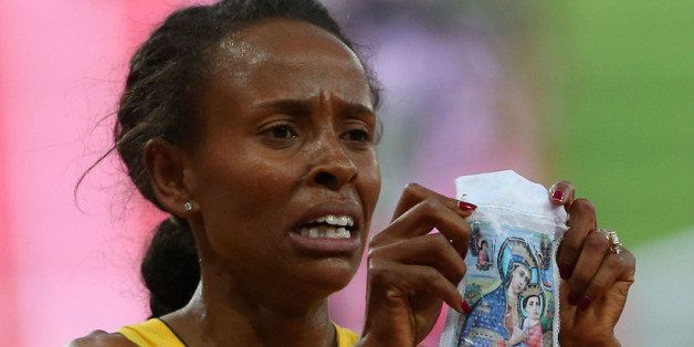 LONDON, ENGLAND - AUGUST 10: Meseret Defar of Ethiopia holds up a picture as she celebrates winning gold in the Women's 5000m Final on Day 14 of the London 2012 Olympic Games at Olympic Stadium on August 10, 2012 in London, England. (Photo by Alexander Hassenstein/Getty Images)