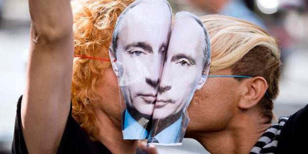 Demonstrators wearing masks depicting Russian President Vladimir Putin kiss as they take part in a rally in front of the Russ