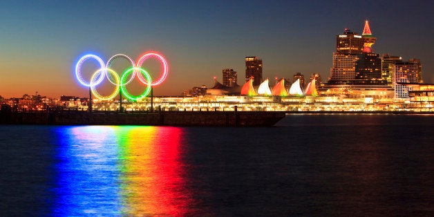 The Olympic Rings light up Coal Harbor/Harbour in front of Canada Place and downtown Vancouver at dawn. Vancouver British Col