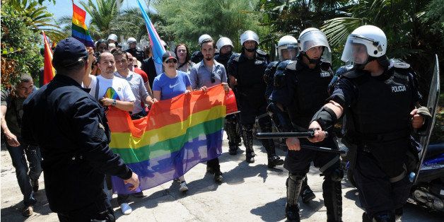 A Montenego riot police protect participants of the first gay pride parade held in the highly conservative Adriatic country that has started membership talks with Brussels, on July 24, 2013 in Budva. More than 100 anti-gay protestors, mostly young hardline football fans, chanted 'Kill the gays!' while throwing stones and bottles towards several dozen gay activists secured by a police cordon in the historic centre of the coastal town Budva. AFP PHOTO / SAVO PRELEVIC (Photo credit should read SAVO PRELEVIC/AFP/Getty Images)