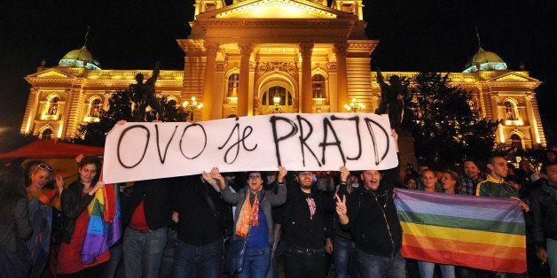 Gay rights activists hold a banner reading 'This is pride' as they demonstrate in front of the Serbian Parliament on late September 27, 2013 in Belgrade. Serbia on September 27, 2013 banned Gay Pride for the third year running, saying the risk of allowing the parade to go ahead was too high. Following the ban, a few hundred gay activists gathered before Serbian government building late on September 27 carrying a huge banner that read 'This is pride.' Escorted by dozens of policemen in anti-riot gear, the group then marched throughout downtown Belgrade to the Serbian parliament building, holding a huge flag in rainbow colours. AFP PHOTO / ANDREJ ISAKOVIC (Photo credit should read ANDREJ ISAKOVIC/AFP/Getty Images)