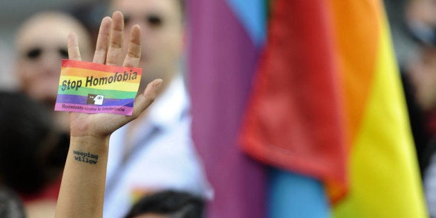 A demonstrator brandishes a rainbow flag sticker as he protests against homophobia and repression against gays in Russia, outside the Ministry of Foreign Affairs and Cooperation in Madrid on September 3, 2013. About 300 gay rights activists rallied in Madrid today as part of an international protest against hotly disputed Russian laws cracking down on homosexual behaviour. AFP PHOTO/ CURTO DE LA TORRE (Photo credit should read CURTO DE LA TORRE/AFP/Getty Images)