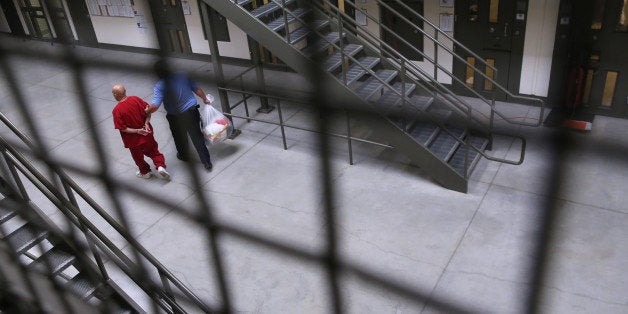 ADELANTO, CA - NOVEMBER 15: A guard escorts an immigrant detainee from his 'segregation cell' back into the general populatio