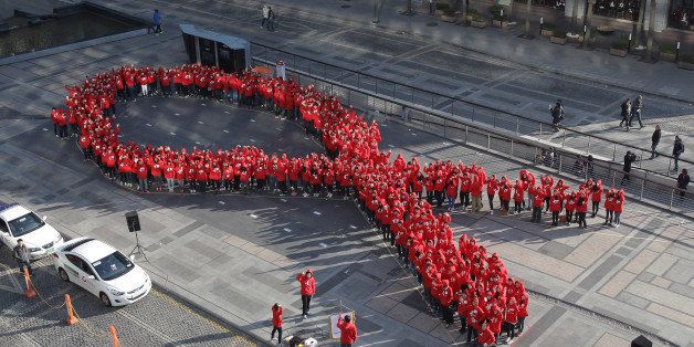 SEOUL, SOUTH KOREA - DECEMBER 01: South Korean students pose in the shape of the 'aids ribbon' during an event to promote the awareness of Aids at Cheonggyecheon on December 1, 2013 in Seoul, South Korea. Seoul Metropolitan Government and other Korea Federation for HIV/AIDS Prevention will hold a AIDS awareness campaign in downtown Seoul to mark the 26th commemoration of World Aids Day on December 1. (Photo by Chung Sung-Jun/Getty Images)