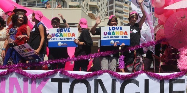 People stand on a float holding signs saying 'Love Uganda, hate homophobia' in reaction to Uganda's law banning homosexuality. Hundreds of people gathered on the streets of Green Point in Cape Town, South Africa, on March 1, 2014 to take part in the 2014 Gay Pride Parade. AFP PHOTO/JENNIFER BRUCE (Photo credit should read JENNIFER BRUCE/AFP/Getty Images)