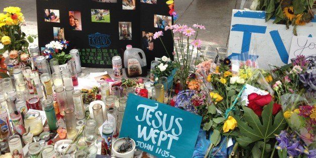 Photos, candles, signs, and other mementos are placed at a makeshift memorial in front of IV Deli Mart, where Christopher Michaels-Martinez was slain in a massacre in Isla Vista, California.