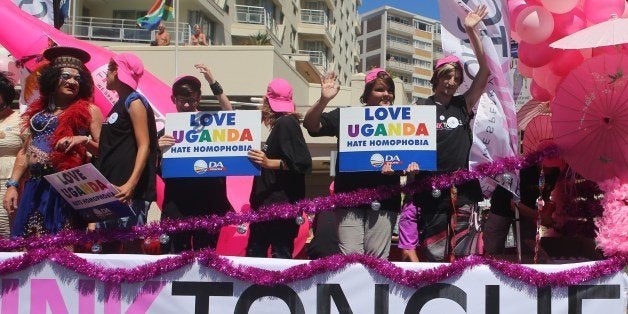 People stand on a float holding signs saying 'Love Uganda, hate homophobia' in reaction to Uganda's law banning homosexuality