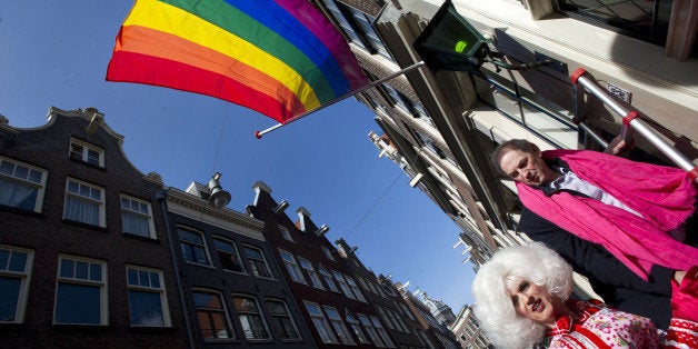 Former Amsterdam Mayor Job Cohen (R) walks in a street below a rainbow flag in Amsterdam, on April 7, 2013, prior to a protest organised by the gay interest organization COC. Protesters demonstrated against a controversial law seen as anti-gay in Russia during Russian President Vladimir Putin's visit to the Netherlands. AFP PHOTO/ANP/ EVERT ELZINGA netherlands out (Photo credit should read EVERT ELZINGA/AFP/Getty Images)