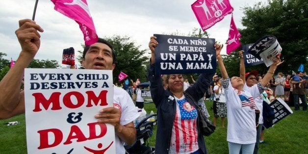 Family members cheer in support of traditional marriage during the second annual 'March for Marriage' June 19, 2014 at the US Capitol in Washington, DC. Americans from all across the country rallied in Washington to call attention to marriage between one man and one woman, saying it is critical for society because children deserve the love and care of both a mother and a father. AFP PHOTO / Karen BLEIER (Photo credit should read KAREN BLEIER/AFP/Getty Images)