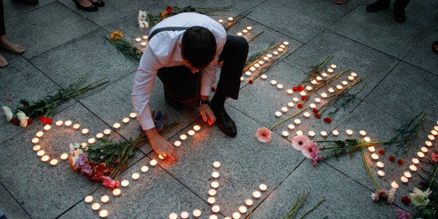 KUALA LUMPUR, MALAYSIA - JULY 21: An Ukranian man lights up candles during a candle light vigil for the victims of MH17 on J