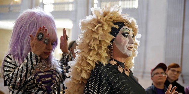 Drag queens Sister Roma, right, speaks as Heklina, left, adjusts her hair during a news conference about their battle with Facebook at City Hall Wednesday, Sept. 17, 2014, in San Francisco, Calif. San Francisco drag queens are sparring with Facebook over its policy requiring people to use their real names, rather than drag names such as Pollo Del Mar and Heklina. In recent weeks, Facebook has been deleting the profiles of self-described drag queens and other performers who use stage names because they did not comply with the social networking site's requirement that users go by their "real names" on the site. (AP Photo/Eric Risberg)