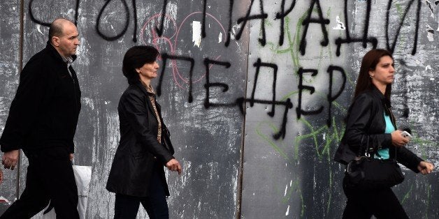 Pedestrian walk past a anti-gay graffiti, reading 'Stop the parade of fags', in Belgrade on September 26, 2014. Belgrade will host a Gay Pride parade on September 28 for the first time in four years after being banned for security reasons following violent protests by ultra-nationalists at the event. Ultra-nationalists and far-right groups have threatened to protest against the gay pride over the weekend, but Prime Minister Aleksandar Vucic warned that 'whoever tries to provoke incidents will be very, very severely punished.' AFP PHOTO / ANDREJ ISAKOVIC (Photo credit should read ANDREJ ISAKOVIC/AFP/Getty Images)