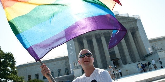 A gay rights activist waves a rainbow flag in front of the US Supreme Court in Washington,DC on June 25, 2013. The high court convened again today to rule on some high profile decisions including including two on gay marriage and one on voting rights. AFP PHOTO/Nicholas KAMM (Photo credit should read NICHOLAS KAMM/AFP/Getty Images)