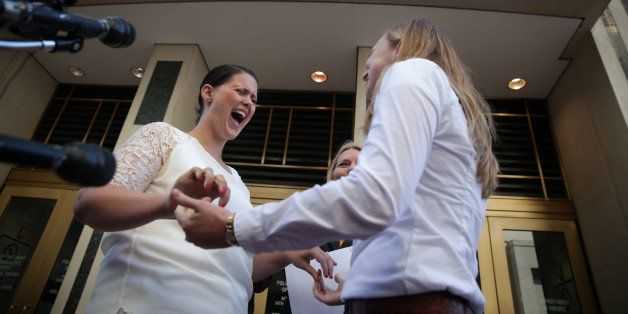 ARLINGTON, VA - OCTOBER 06: Erika Turner (R) and Jennifer Melsop (L) of Centreville, Virginia, becomes the first same sex marriage couple in Arlington County during a ceremony, officiated by the Rev. Linda Olson Peebles (C) of Unitarian Universalist Church of Arlingon, outside the Arlington County Courthouse October 6, 2014 in Arlington, Virginia. The U.S. Supreme Court announced that it will not hear the five pending same-sex marriage cases, paving the way for gay and lesbian marriage in 11 more states. (Photo by Alex Wong/Getty Images)
