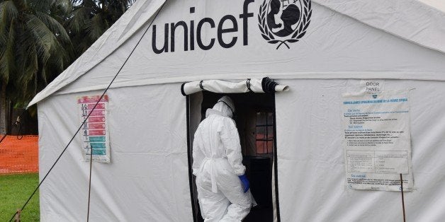 A man in full protective gear enters a tent in the Ebola treatment unit being preventively set to host potential Ebola patien