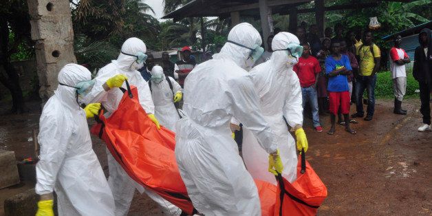 Health workers carry the body of a man suspected to have died of Ebola virus in Paynesville Community situated on the outskirts of Monrovia, Liberia, Tuesday, Oct. 21, 2014. Liberian President Ellen Johnson Sirleaf said Ebola has killed more than 2,000 people in her country and has brought it to "a standstill," noting that Liberia and two other badly hit countries were already weakened by years of war. (AP Photo/Abbas Dulleh)