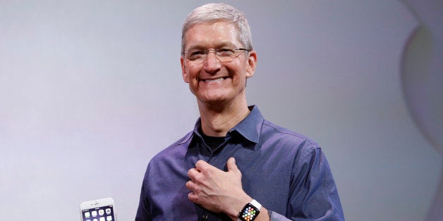 Apple CEO Tim Cook, holding an IPhone 6 Plus, discusses the new Apple Watch and iPhone 6s on Tuesday, Sept. 9, 2014, in Cupertino, Calif. (AP Photo/Marcio Jose Sanchez)