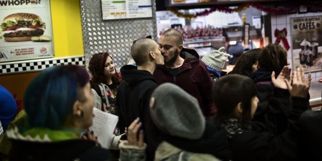 Same sex couples kiss inside a Burger King restaurant in Madrid, Spain, Saturday, Dec. 6, 2014 . People supporting the fight against homophobia gathered on Saturday in a restaurant to protest against the decision of a security guard that asked a gay couple to leave the place after they kissed. (AP Photo/Daniel Ochoa de Olza)