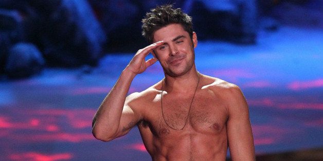 Zac Efron accepts the award for best shirtless performance for âThat Awkward Momentâ on stage at the MTV Movie Awards on Sunday, April 13, 2014, at Nokia Theatre in Los Angeles. (Photo by Matt Sayles/Invision/AP)