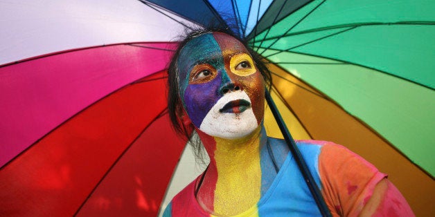 An Indonesian activist with painted face holds an parasol during a protest demanding equality for LGBTIQ (Lesbian, gay, bisexual, transgender and questioning) people in Medan, North Sumatra, Indonesia, Friday, May 31, 2012. Homosexuals and transgenders in the world's most populous Muslim country are often faced with discriminations and abuses. (AP Photo/Binsar Bakkara)