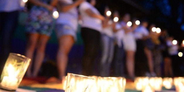 TO GO WITH AFP STORY: Philippines-US-diplomacy-crime-discrimination-sex,FEATURE by Mynardo MacaraigIn this photo taken on October 25, 2014 shows mebers and supporters of Lesbian,gay and bisexual, transgender (LGBT) community attending a candle vigil during a protest inside the state university campus in Manila, against the killing of a Filipino transgender woman allegedly by a US marine. The murder of a Filipina transgender woman, allegedly by a US Marine, has stoked nationalist outrage in the Philippines but activists say the spotlight should also be shone on the dangers faced by the gay community at home. AFP PHOTO/TED ALJIBE (Photo credit should read TED ALJIBE/AFP/Getty Images)