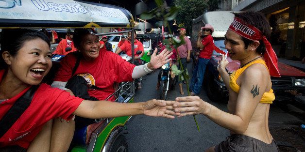 BANGKOK THAILAND- MARCH 20: A gay man enjoys the festive scene as thousands of Red shirt supporters of former PM Thaksin Shinawatra parade through the streets on March 20, 2010 in Bangkok,Thailand. They rolled through the capital city in cars, motorcycles and trucks to recruit more supporters as they hold a 7th day of peaceful protests against the government and demanding fresh elections. Thaksin's government was ousted in a military coup in 2006, the Thai government said that Thaksin's abuse of his power allowed him and his firms to benefit from the Shin Corp. communications company. (Photo by Paula Bronstein /Getty Images)