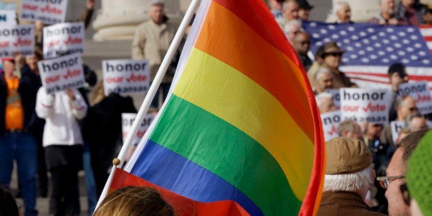 FILE - In this Nov. 19, 2014, file photo, supporters of Arkansas' law banning same sex marriage, top, hold a rally as a protestor waves a rainbow flag at the Arkansas state Capitol in Little Rock, Ark. Americans are slightly more likely to favor than oppose allowing gay and lesbian couples to legally marry, a new Associated Press-GfK poll finds, but most believe wedding-related businesses should be allowed to deny service to same-sex couples for religious reasons. (AP Photo/Danny Johnston, File)